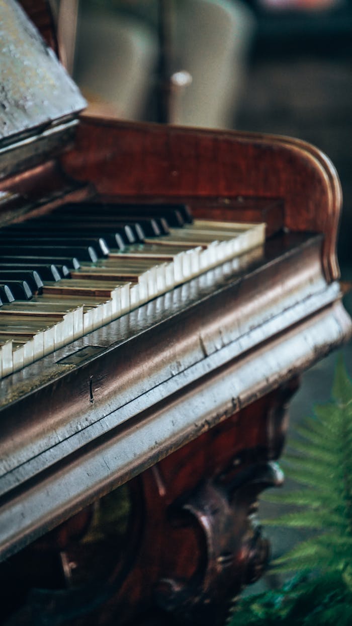 Detailed view of a vintage grand piano focusing on the keys with a rustic ambiance.